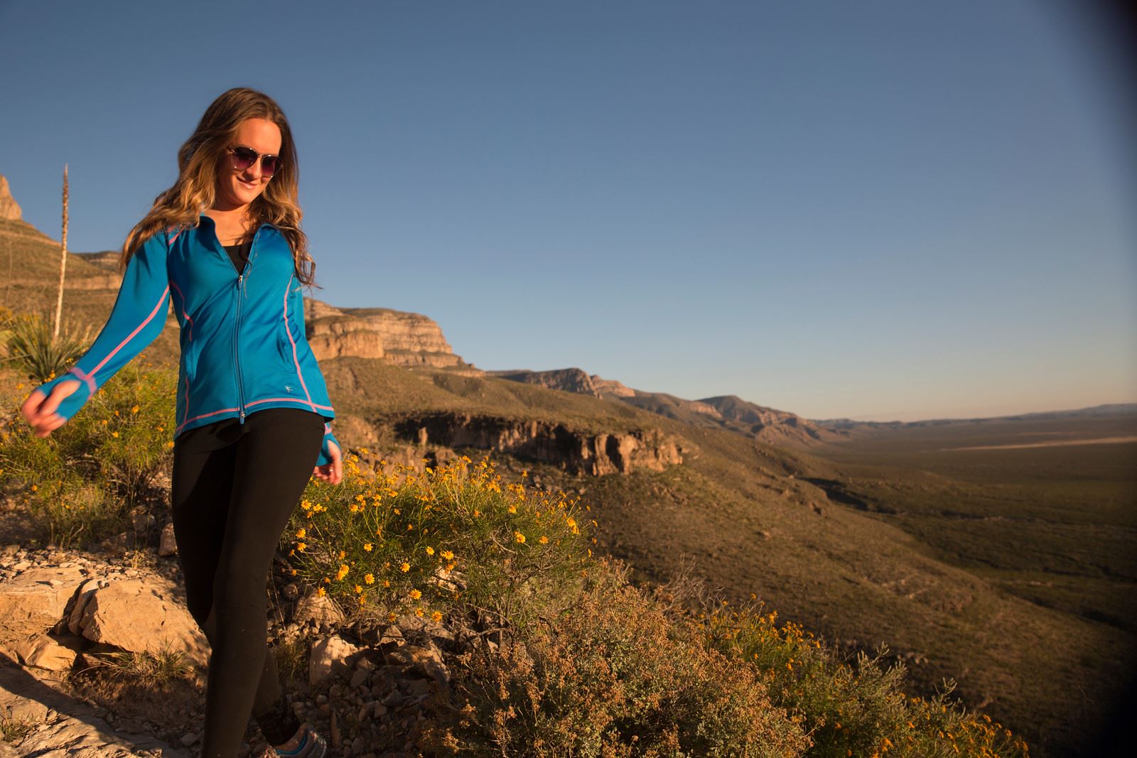 A woman hiking in a mountain terrain.