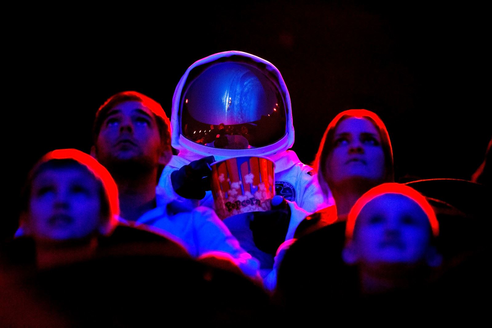 An astronaut and four people looking up inside the planetarium.